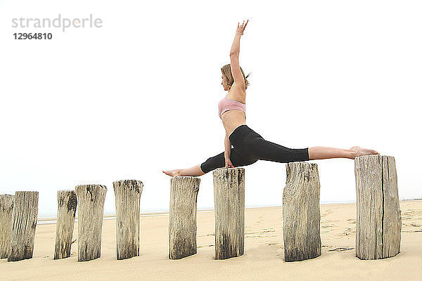 Junge Frau am Strand. Stretching