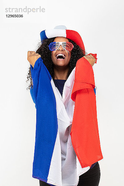 Porträt eines jungen Anhängers der französischen Fußballmannschaft  der einen Hut  eine Trikolore-Brille und eine Fahne seiner Mannschaft trägt