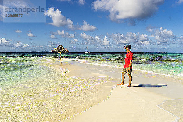 Ein Mann steht am Strand von Morpion's Island  St-Vincent  St. Vincent und die Grenadinen  Kleine Antillen  Westindische Inseln  Inseln über dem Winde  Karibik  Mittelamerika