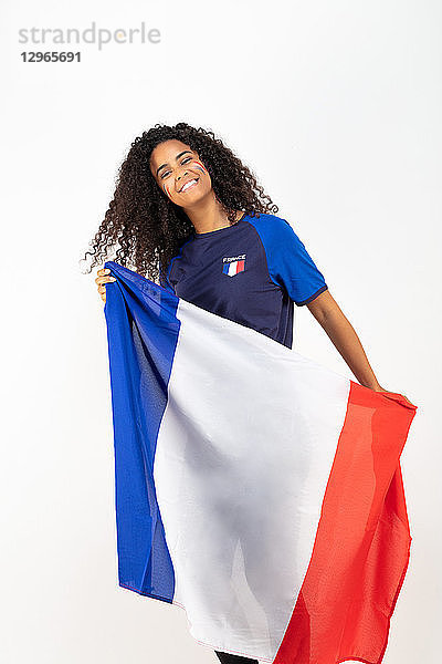 Porträt eines jungen Anhängers der französischen Fußballmannschaft  der die Trikolore hält