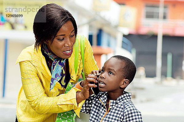 Eine junge Frau  die ihre Kommunikation durch ihr Kind abhören lässt.