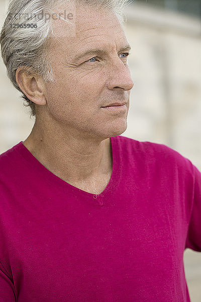 Porträt eines gut aussehenden lässigen Mannes in fuchsiafarbenem Pullover