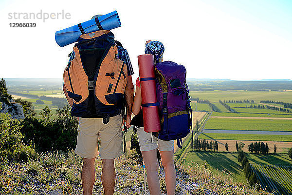 Ein junges Paar wandert auf einem Abenteuertrek und betrachtet die schöne Landschaft bei Sonnenuntergang.