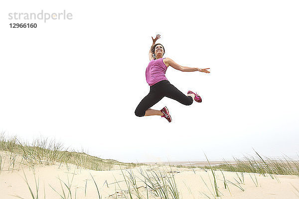 Junge Frau am Strand. Springen