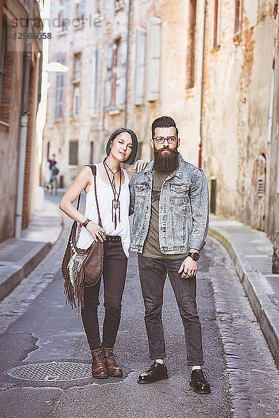 Junges Hipster-Paar geht Arm in Arm auf der Straße