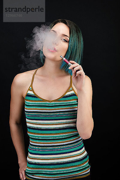 Junge Frau dampft eine elektronische Zigarette