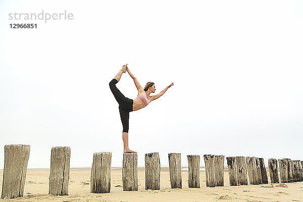 Junge Frau am Strand. Stretching