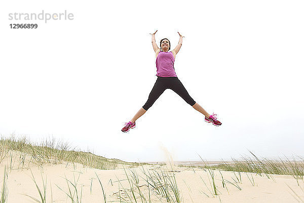 Junge Frau am Strand. Springen