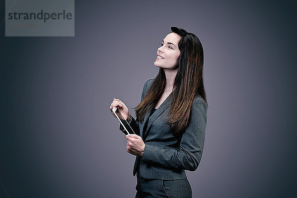 Porträt einer lächelnden jungen Geschäftsfrau  ein Touchpad in den Händen
