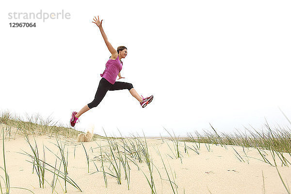 Junge Frau am Strand. Springen