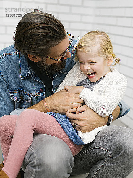 Mann kitzelt seine Tochter