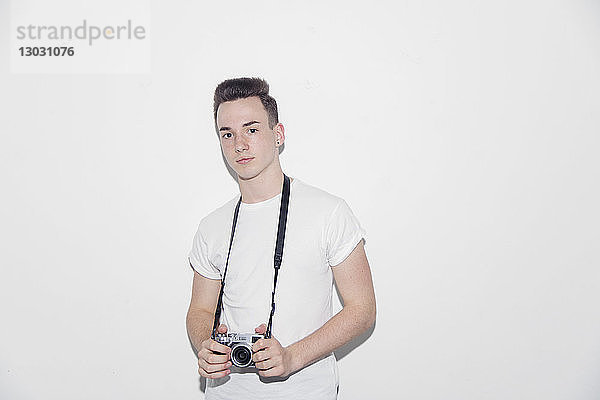 Porträt eines selbstbewussten  coolen Teenagers mit Retro-Kamera