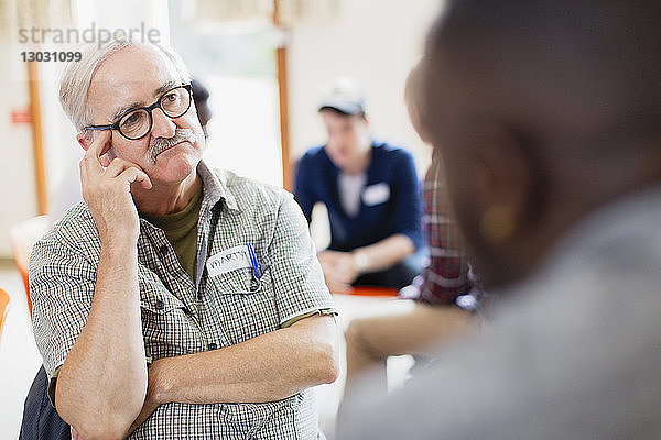 Aufmerksamer älterer Mann hört in der Gruppentherapie zu