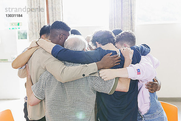 Männer stehen in einer Gebetsgruppe zusammen