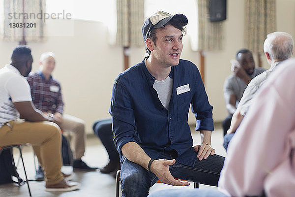 Junger Mann spricht in Gruppentherapie im Gemeindezentrum