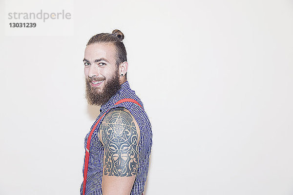 Porträt selbstbewusster männlicher Hipster mit Schultertattoo