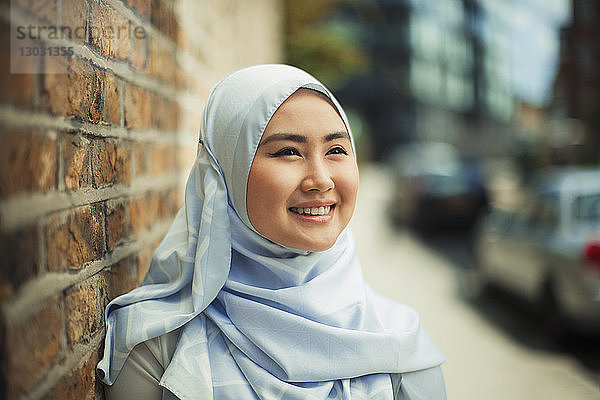 Porträt lächelnde  selbstbewusste junge Frau in blauem Seiden-Hijab