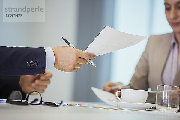 Geschäftsleute mit Papierkram im Meeting