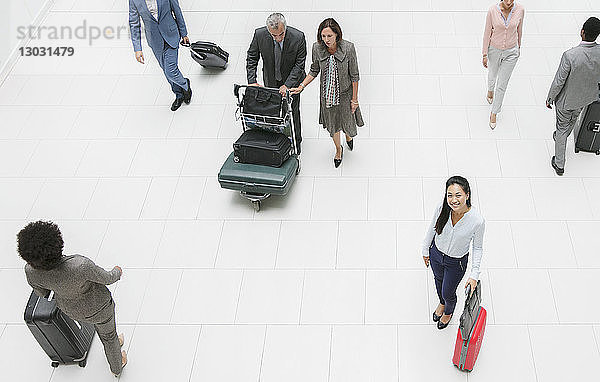 Hohe Winkel Porträt lächelnd Geschäftsfrau mit Koffer im Flughafen