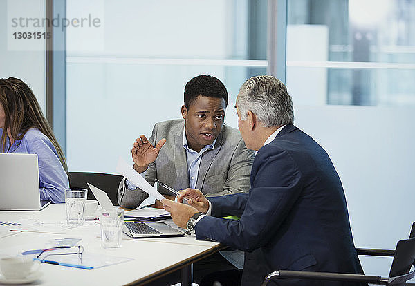 Geschäftsleute besprechen Papierkram in einer Konferenzraumbesprechung