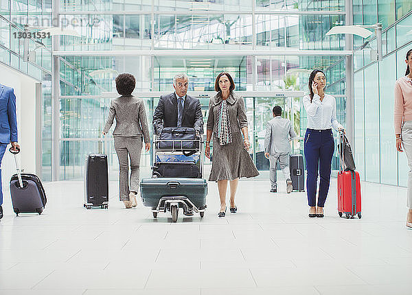 Geschäftsleute gehen mit Gepäck im Flughafen