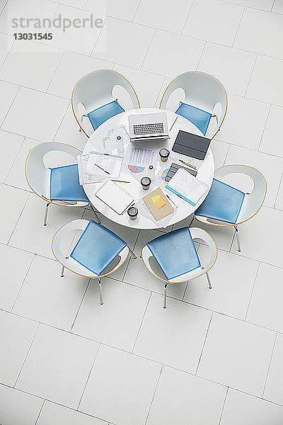 Hohe Winkel Ansicht Business-Laptop und Papierkram auf runden Tisch