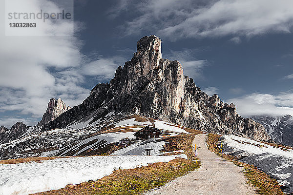 Schotterpiste in schneebedeckten Bergen  Dolomiten  Italien