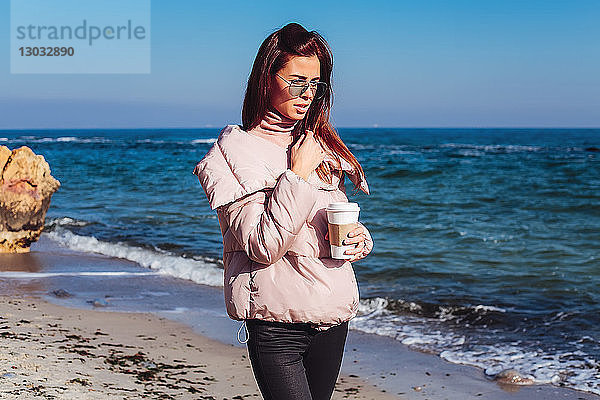 Stilvolle Frau mittleren Alters beim Strandspaziergang mit Kaffee zum Mitnehmen  Odessa  Odeska Oblast  Ukraine