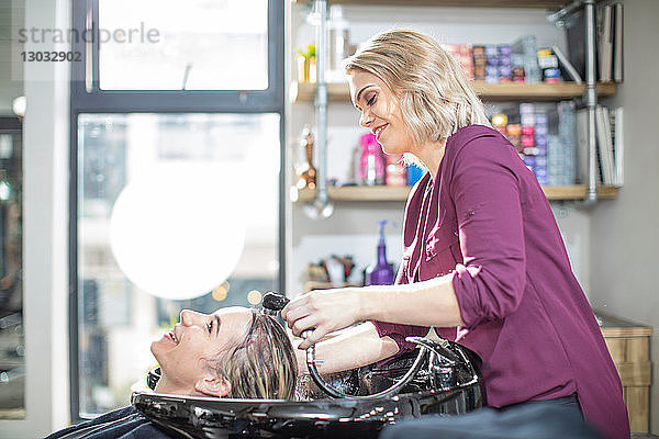 Friseur spült den Kunden im Salon die Haare