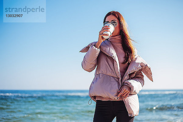 Stylische Frau mittleren Alters am Strand  die Kaffee zum Mitnehmen trinkt  Odessa  Odeska Oblast  Ukraine