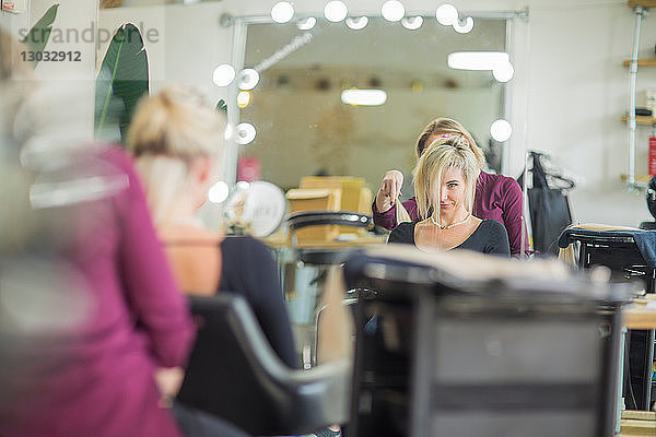 Friseur frisiert die Haare des Kunden im Salon