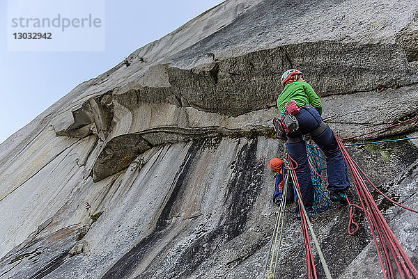 Junge Bergsteigerin beim Klettern an einer Felswand  Niedrigwinkelansicht  The Chief  Squamish  Britisch-Kolumbien  Kanada