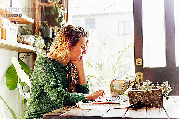 Junge Frau benutzt Laptop im Café