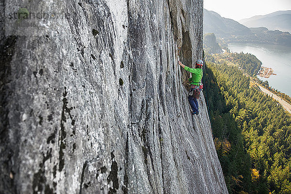 Junge Bergsteigerin beim Klettern an einer Felswand  erhöhte Ansicht  The Chief  Squamish  Britisch-Kolumbien  Kanada