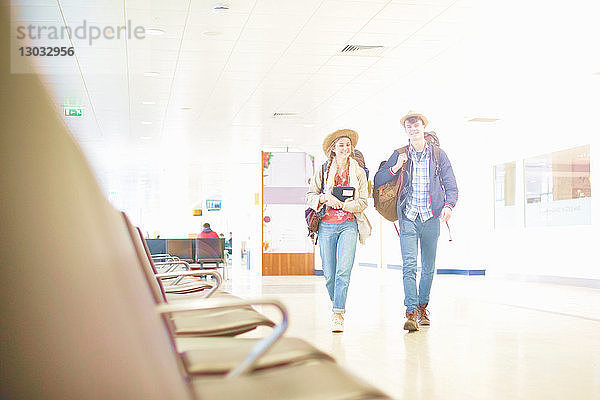 Junges Ehepaar am Flughafen mit Rucksäcken  Blick aus niedrigem Winkel