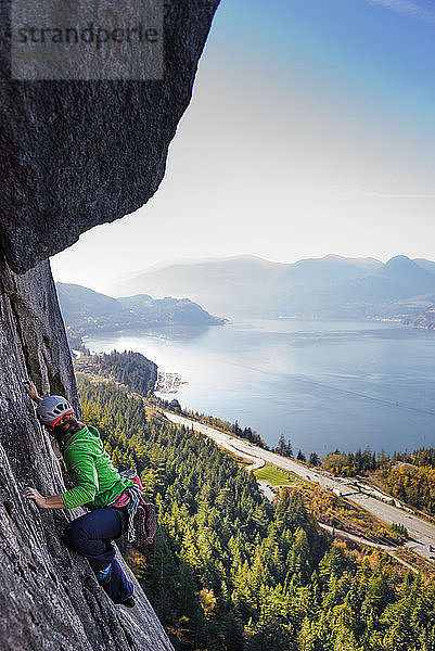 Junge Bergsteigerin beim Klettern an einer Felswand  erhöhte Ansicht  The Chief  Squamish  Britisch-Kolumbien  Kanada