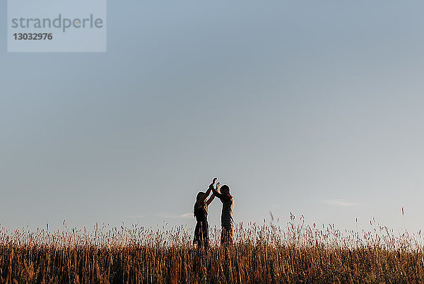 Romantischer Mann und Freundin im Feld aus langem Gras  Fernsicht