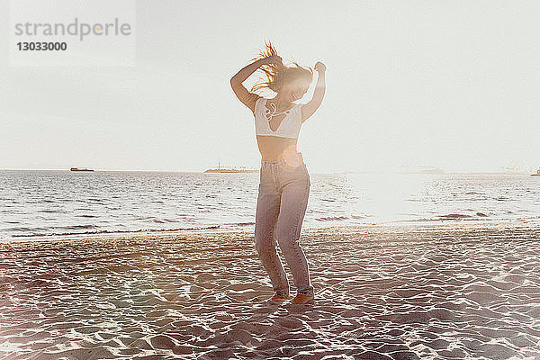 Junge Frau tanzt am Strand