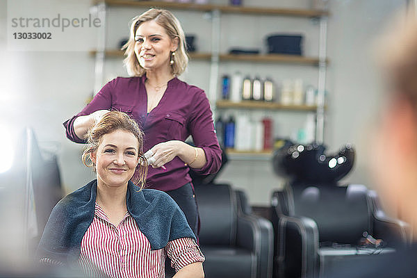 Friseur frisiert die Haare des Kunden im Salon