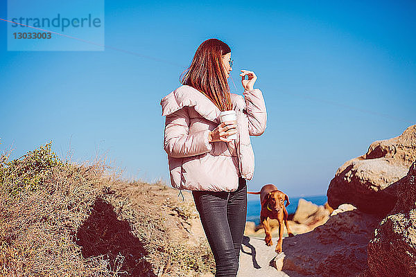 Mittlere erwachsene Frau am Strand beim Spaziergang mit ihrem Hund  Odessa  Odeska Oblast  Ukraine