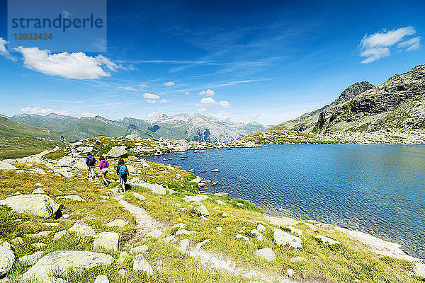 Wanderer auf Wanderweg am Ufer des Bergsees  Splugapass  Kanton Graubünden  Schweiz