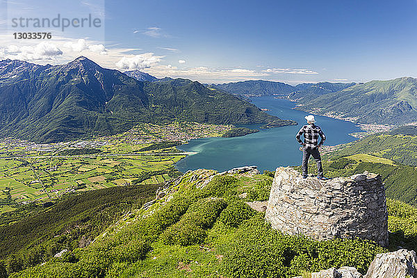 Wanderer auf dem Gipfel des Monte Berlinghera mit Blick auf Colico und den Monte Legnone  Provinz Sondrio  Lombardei  Italien