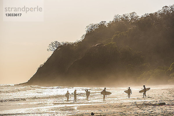 Surfer an einem Strand bei Sonnenuntergang  Nosara  Provinz Guanacaste  Pazifikküste  Costa Rica