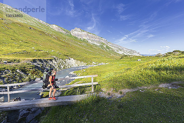 Wanderin läuft über einen Steg  Unterer Segnesboden  Flims  Bezirk Imboden  Kanton Graubünden  Schweiz