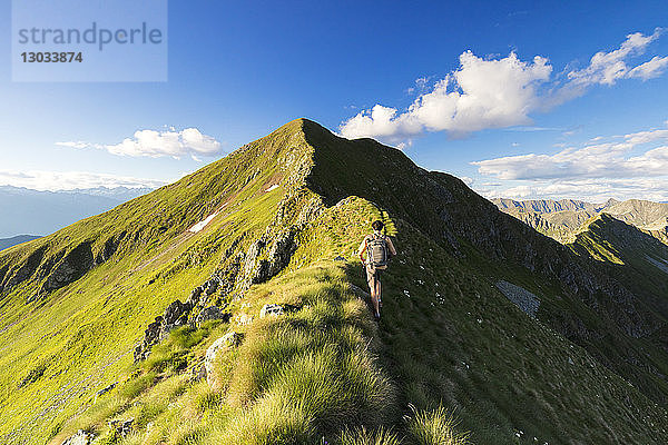 Wanderer auf steilem Grat beim Aufstieg zum Monte Azzarini  San Marco Pass  Albaredo Tal  Orobie Alpen  Lombardei  Italien