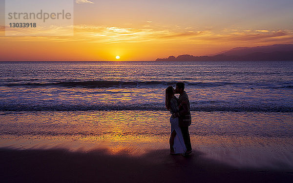 Sonnenuntergang und verliebtes Paar in der Nähe der Golden Gate Bridge  Baker Beach  San Francisco  Kalifornien  Vereinigte Staaten von Amerika  Nordamerika