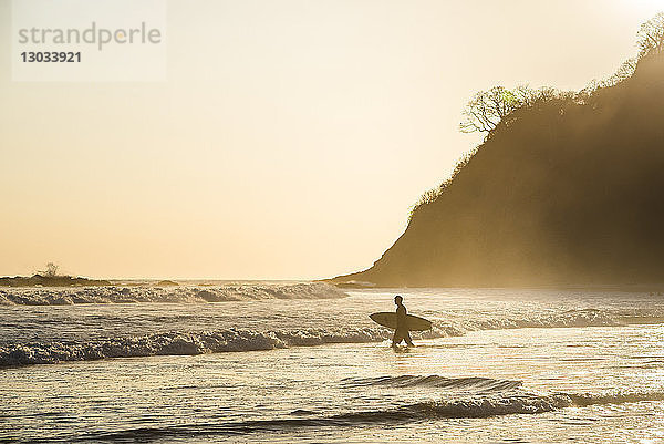 Surfer an einem Strand bei Sonnenuntergang  Nosara  Provinz Guanacaste  Pazifikküste  Costa Rica