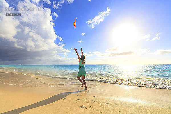 Frau am Strand wirft den Hut in die Luft  Ffryes Beach  Antigua  Antigua und Barbuda  Leeward Islands  Westindische Inseln  Karibik