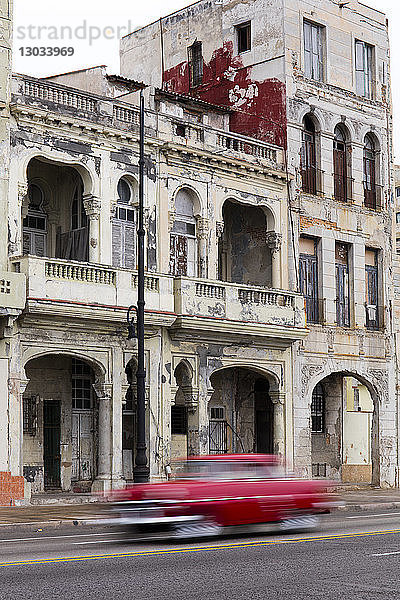 Unscharfer roter Oldtimer auf dem Malecon  Havanna  Kuba  Westindien  Karibik