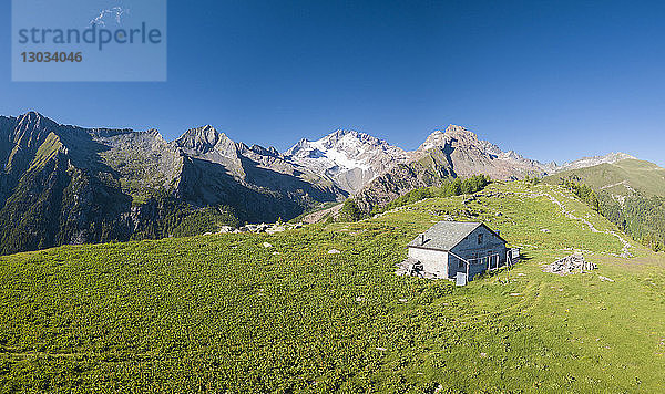 Panorama-Luftaufnahme einer Hütte auf grünen Wiesen  Scermendone Alp  Provinz Sondrio  Valtellina  Rätische Alpen  Lombardei  Italien